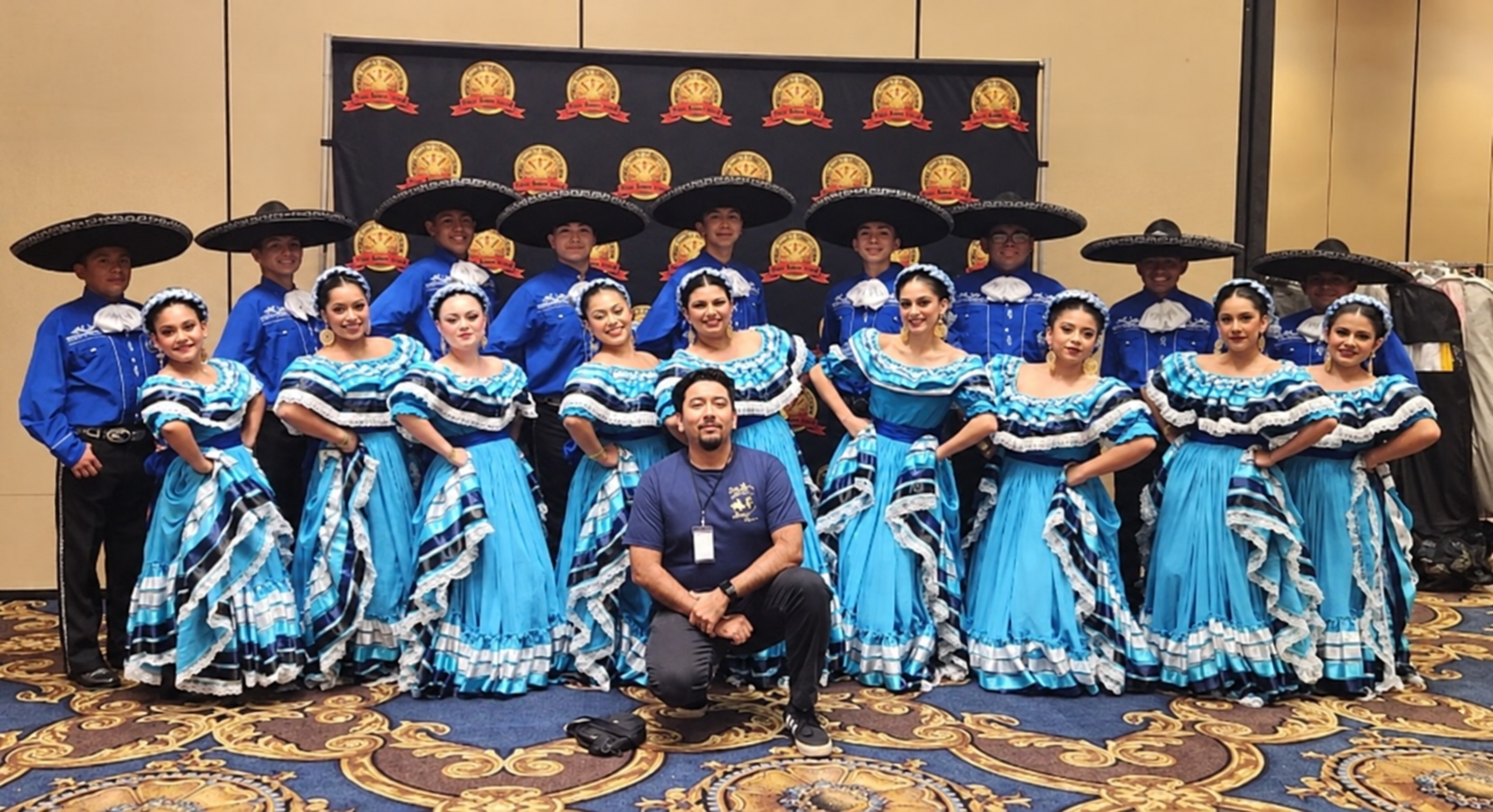 Grupo con vestidos y trajes azules en un salón